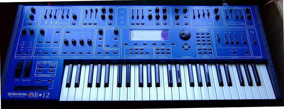 An Oberheim OB-12 synthesizer lit in blue.