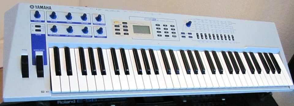 A silver-blue Yamaha CS2x synthesizer.
