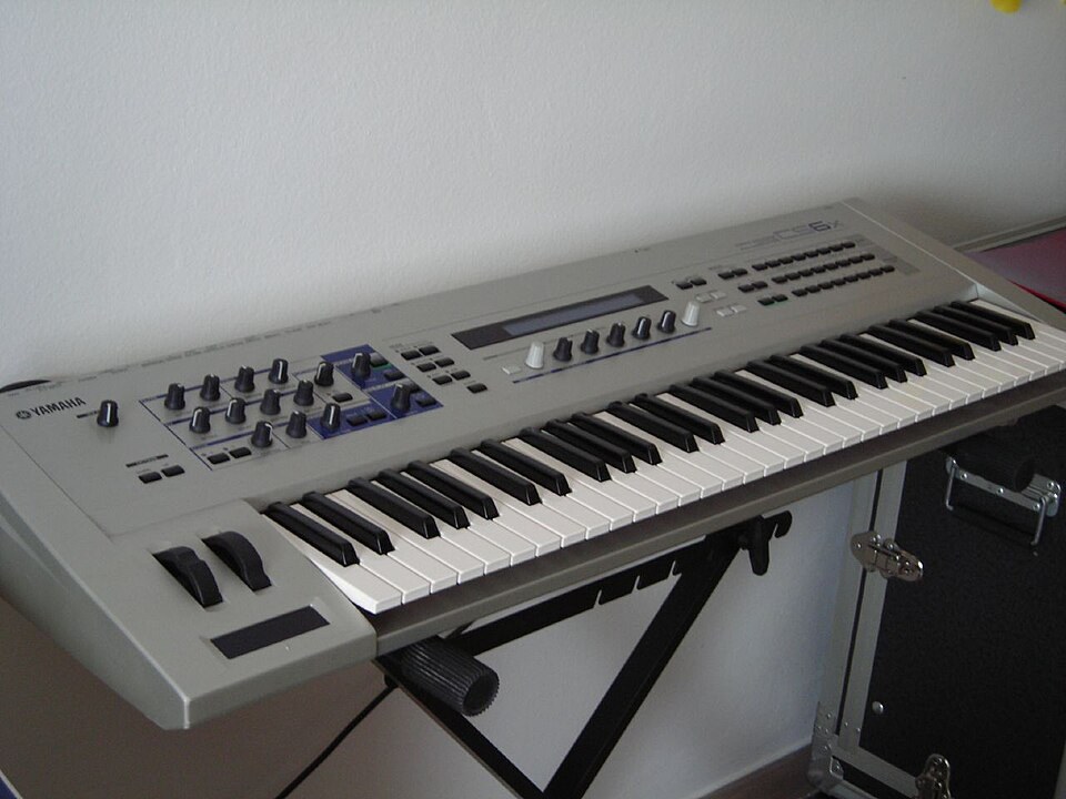 A silver Yamaha CS6x synthesizer on a keyboard stand.