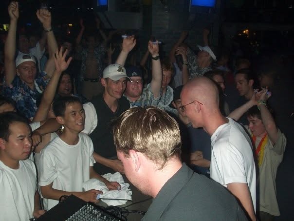 The crowd dancing and cheering next to the performers' table.