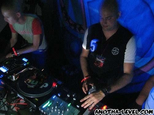 Both members at the decks under blue light.
