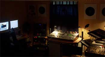 The trance[]control studio in 2001: monitors, racks of synthesizers and a mixing desk in warm, dim light.