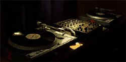 Turntables Turntables and a DJ mixer in low light in the studio.